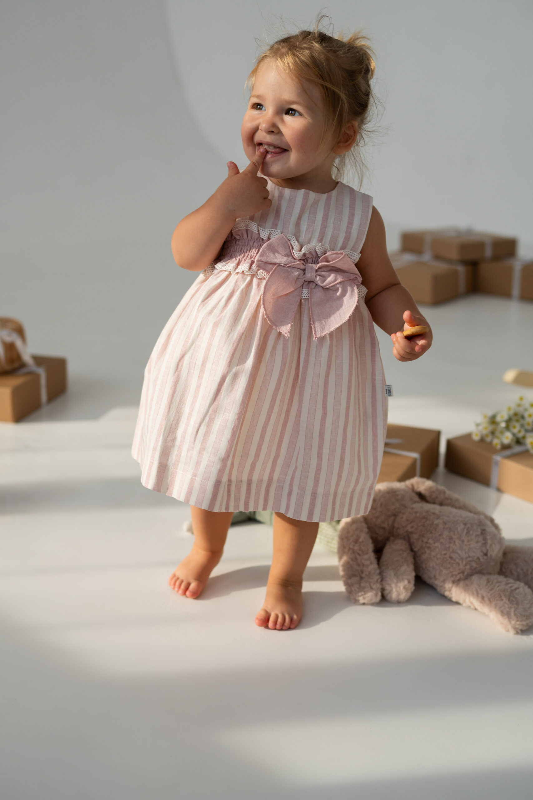 Rochiță bebeluși în dungi roz cu fundă mare Rochiță bebeluși cu dungi roz și fundă mare decorativă