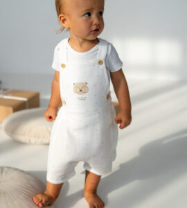 Salopetă bebeluși crem cu bretele și imprimeu ursuleț, din bumbac moale, set cu pălărioară cu urechi, outfit drăgălaș și confortabil pentru copii