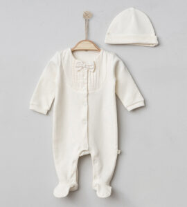 Costumaș elegant pentru bebeluși de culoare albă, cu papion la guler și căciuliță asortată, prezentat pe umeraș.