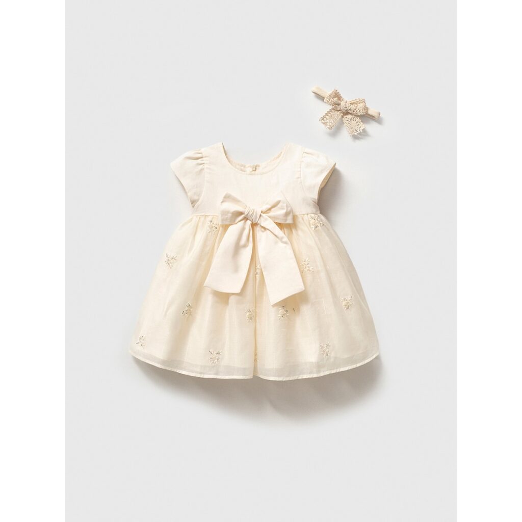 Rochiță elegantă pentru botez fetițe de culoare ivory cu fundă mare în talie și bentiță din dantelă asortată.