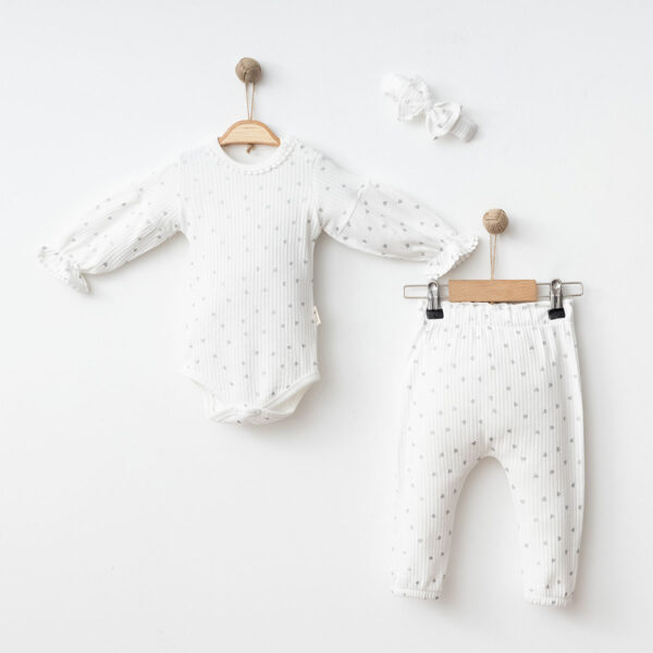 Set haine bebeluși fetițe format din body alb cu inimioare, pantaloni și bentiță cu fundă.