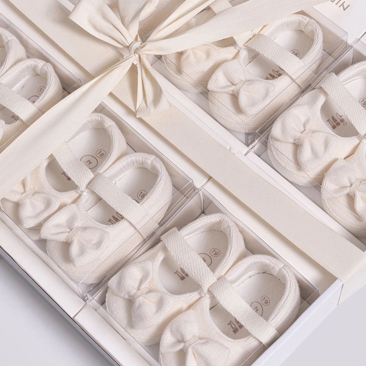 pantofiori-eleganti-bebelusi-fundita-ceremonie-alb Pereche de pantofiori eleganți pentru bebeluși tip balerini cu fundiță albi și bareta elastică în cutie cadou premium.