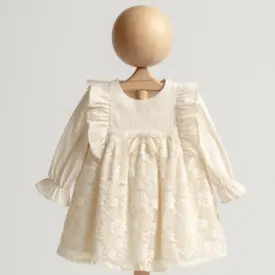 Rochiță elegantă pentru bebeluși din dantelă florală ivory cu volane și mâneci lungi.