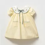 Rochiță galben pal pentru fetițe model Amalfi Limone cu guler alb brodat cu lămâi și fundiță verde.