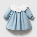 Rochiță albastru pastel denim pentru fetițe cu guler dublu alb brodat, volănașe și mâneci lungi cu manșete elastice.